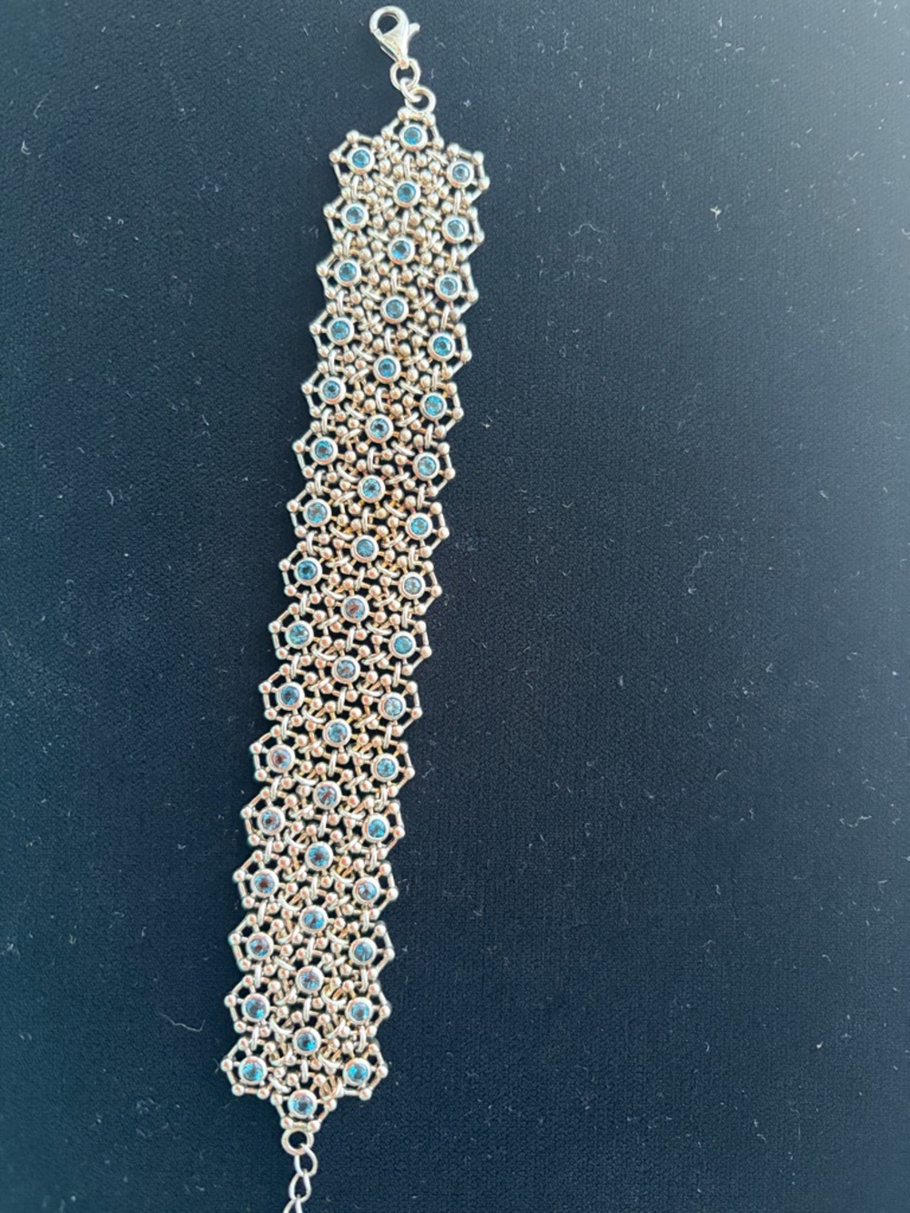 Silver mesh flexible bracelet with blue topaz colored crystals. Sleek Jewelry